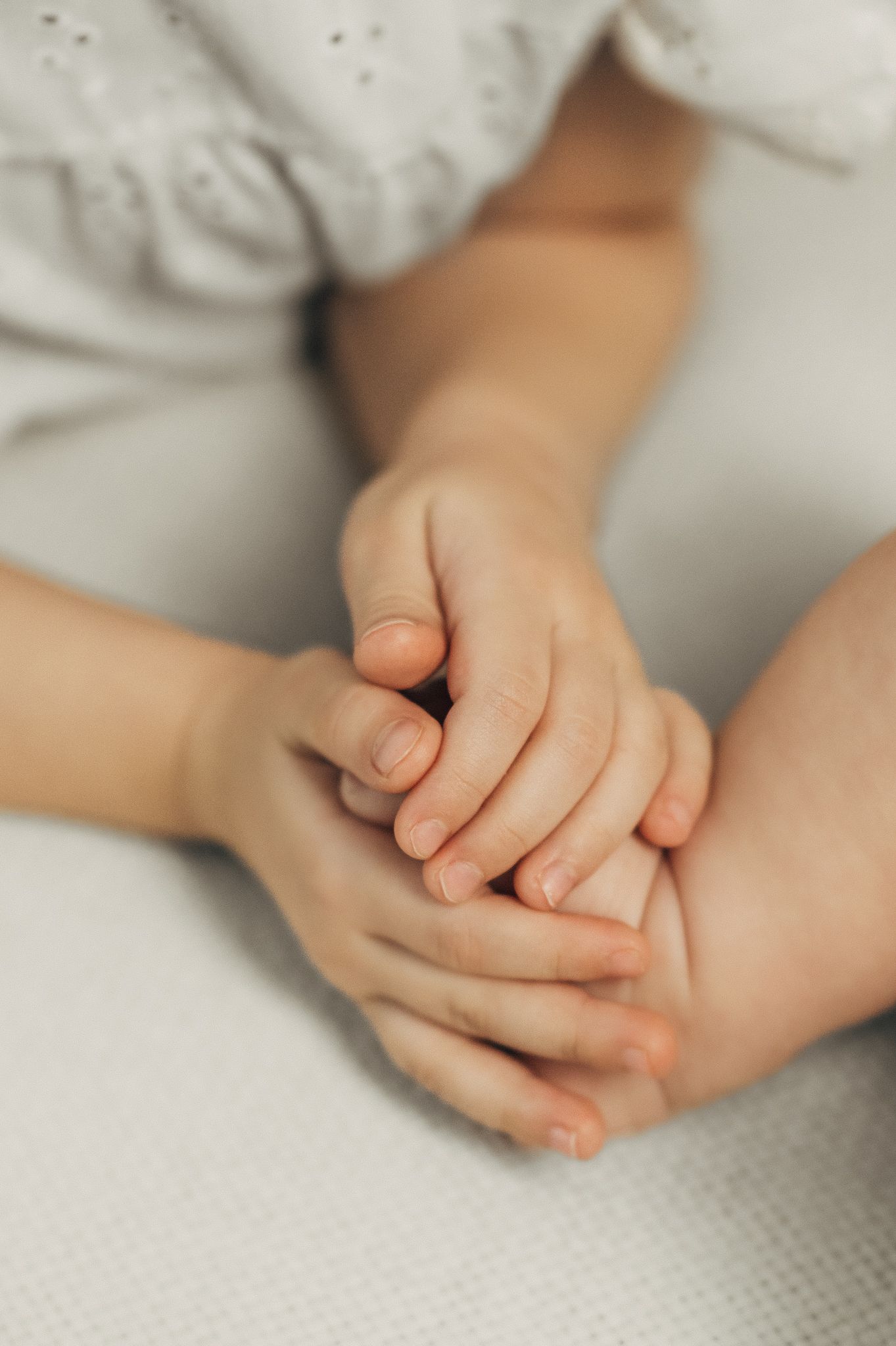 Close-up shots of gentle hands touching in soft, natural light.