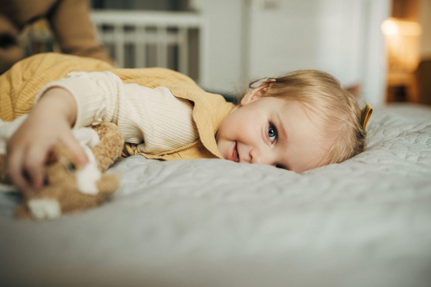 Child and pets resting peacefully together on a white bed.