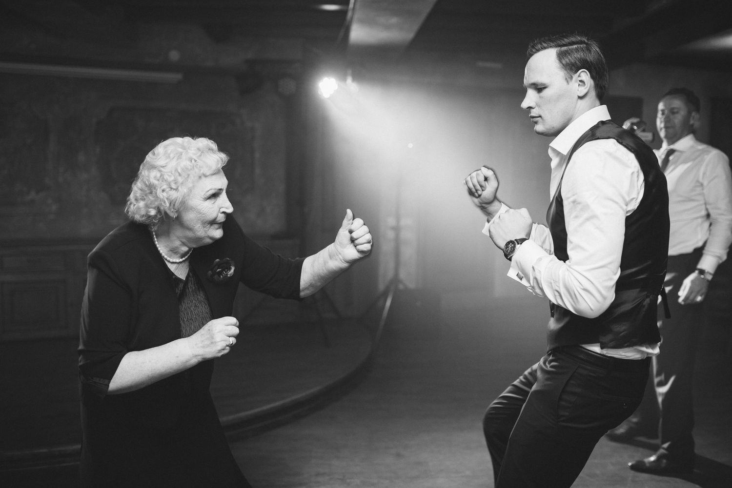 Two people dancing energetically in a dimly lit venue.