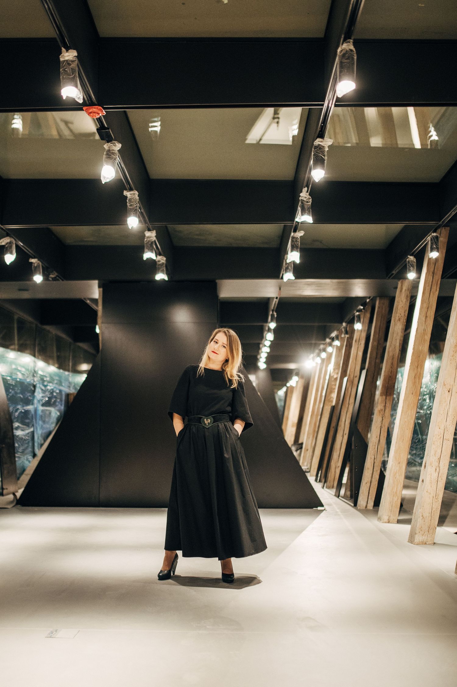 Modern interior hallway with dramatic track lighting and geometric black ceiling design.