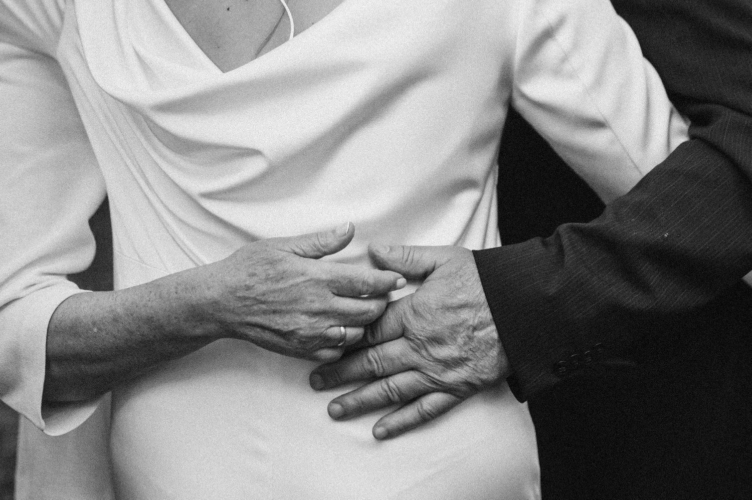 Sequence of black and white photos showing hands gently kneading and massaging a person's shoulder and neck area.