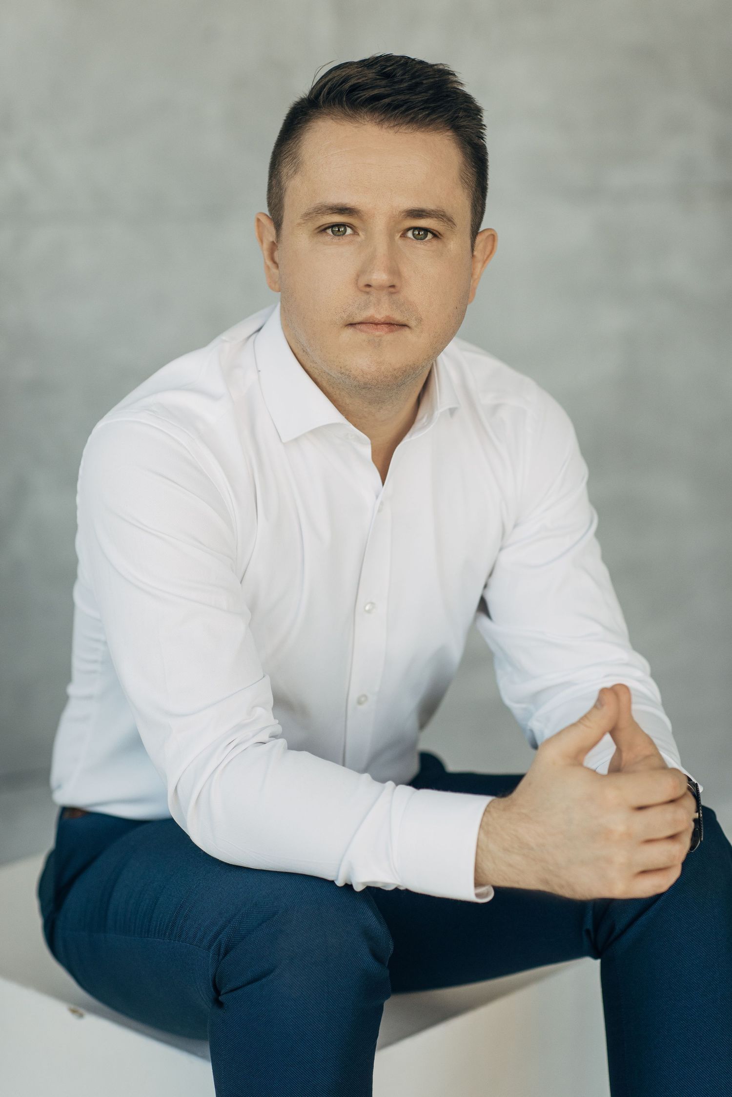 Professional headshots of a person in white shirt and navy pants against gray backdrop.