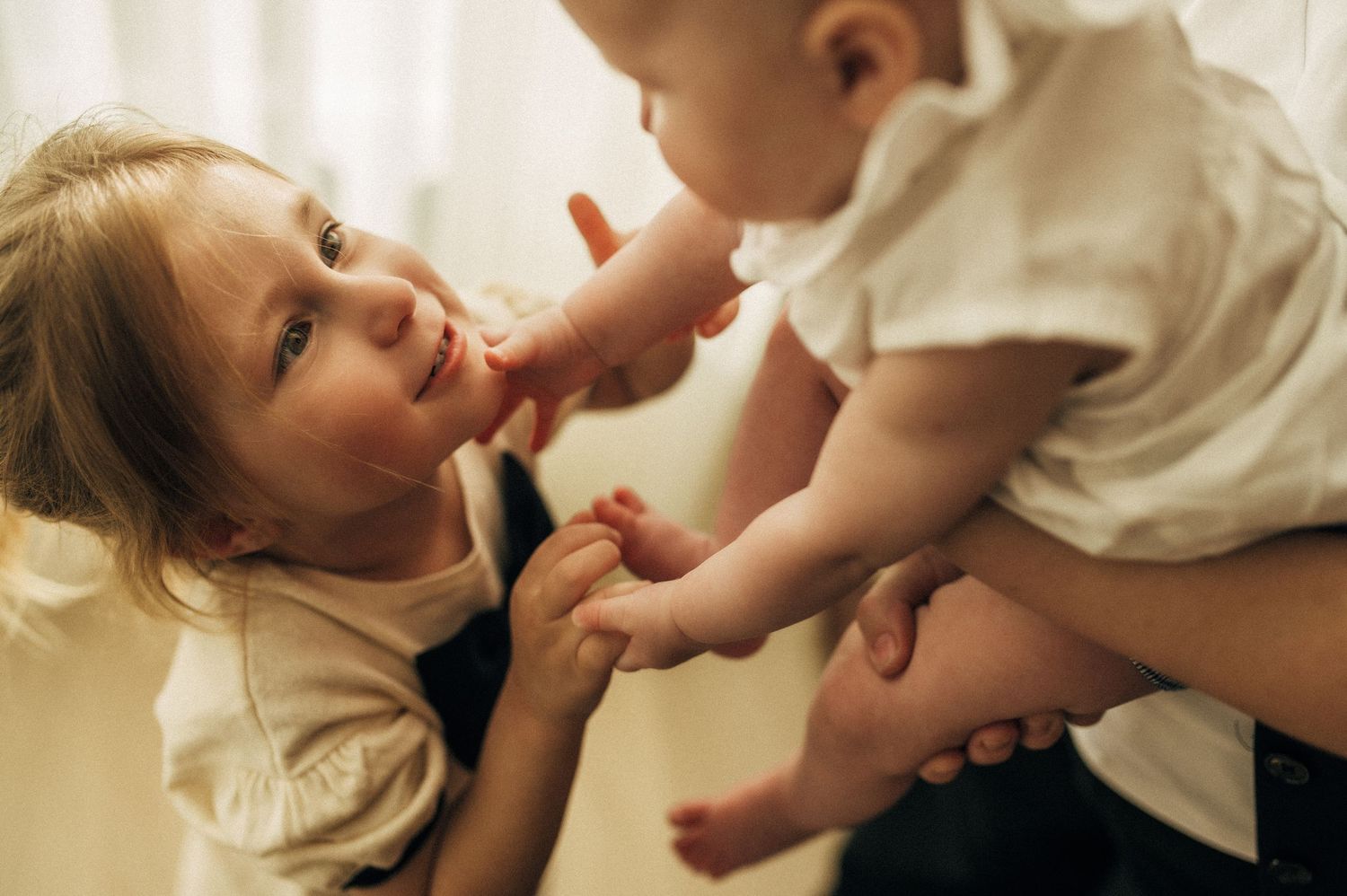Tender candid moments between parent and baby in natural light setting.