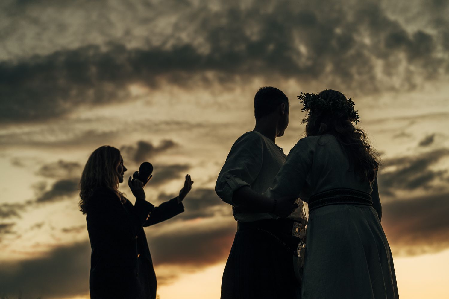 Silhouettes of people against a dramatic sunset sky creating romantic ambiance.