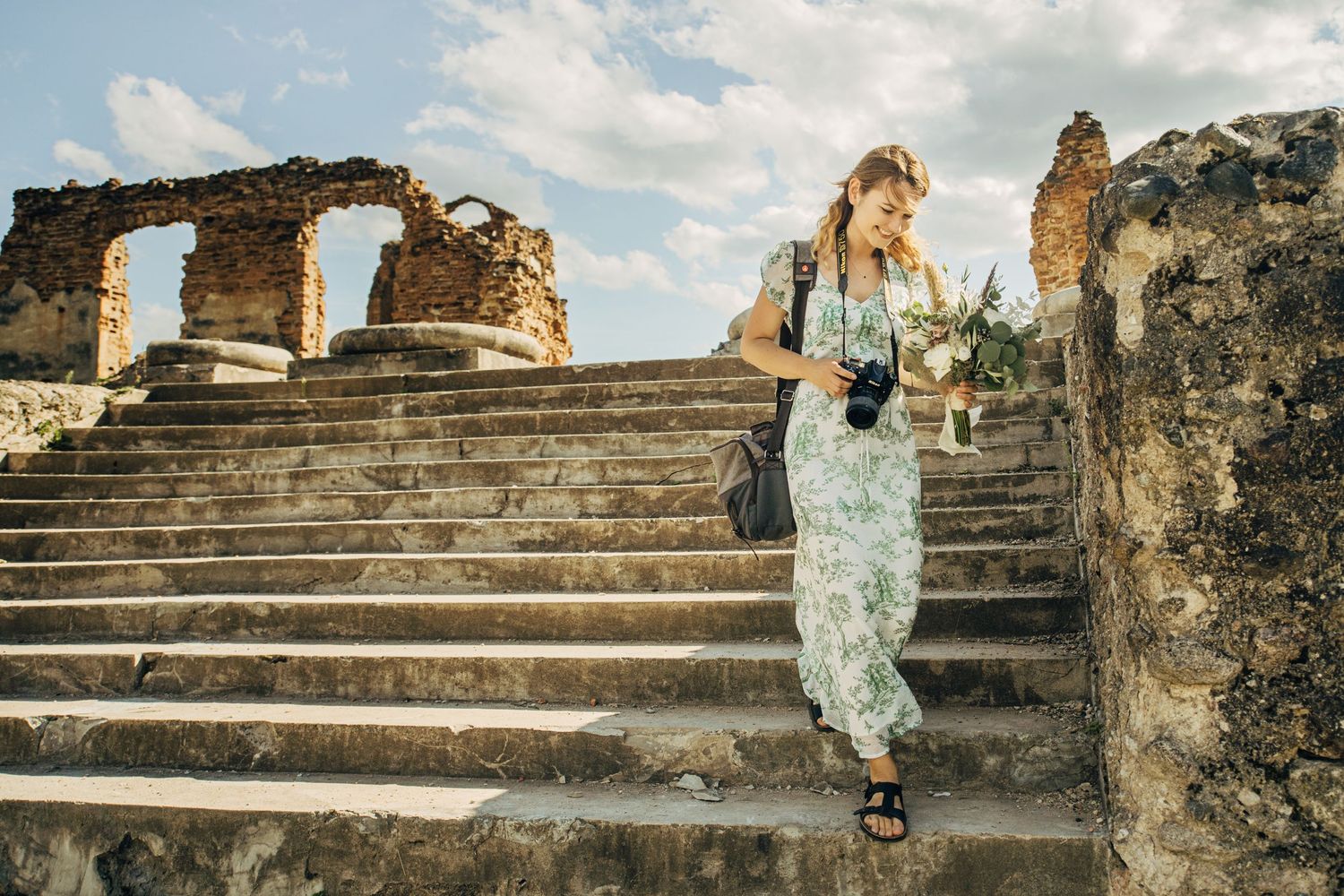 Ancient stone ruins and stairs under cloudy skies at a historic archaeological site.