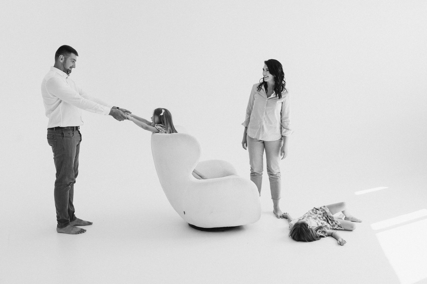 Artistic white studio photography sequence shows movement and interaction between subjects in minimalist setting.