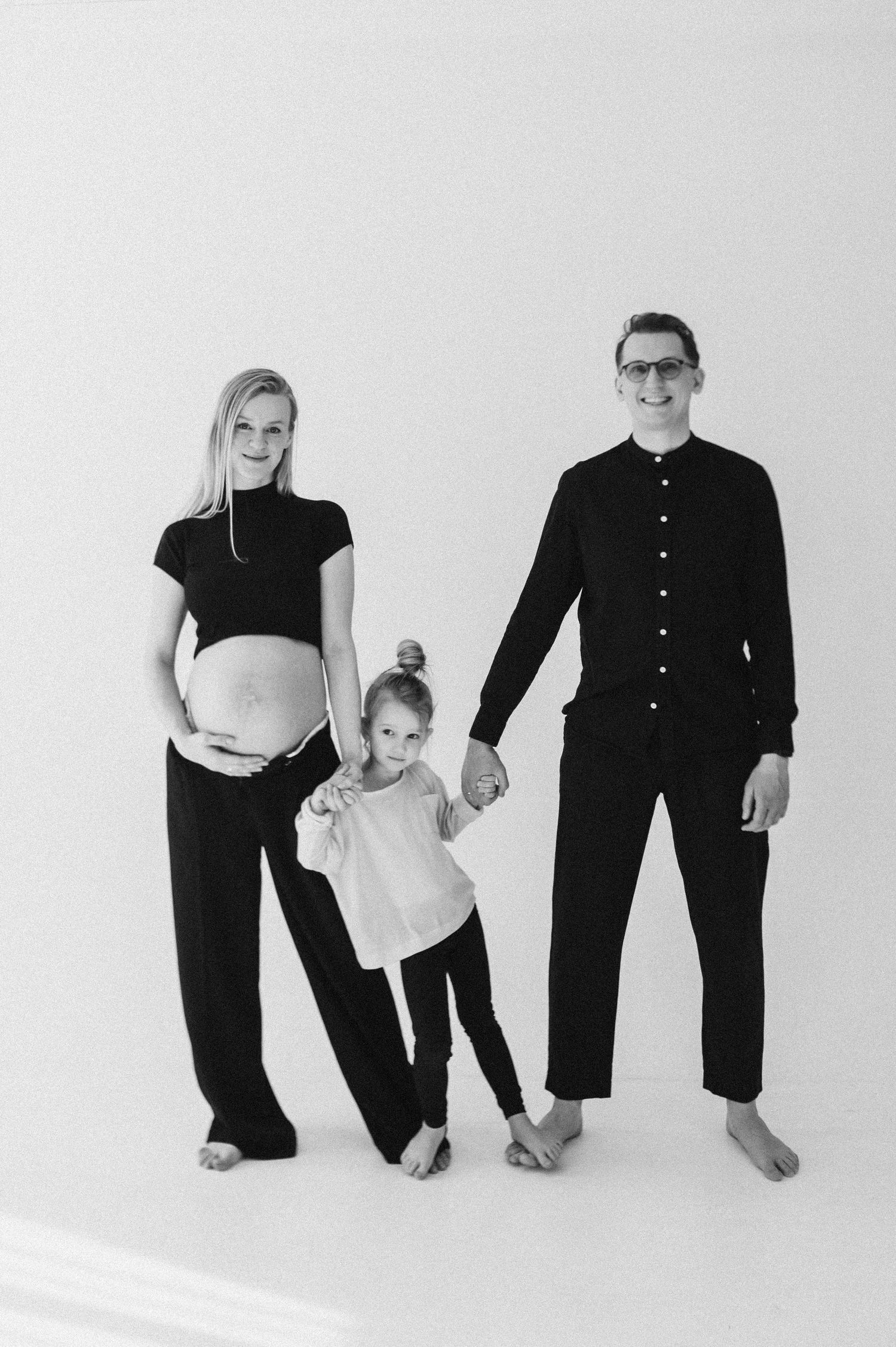 Modern family photo collection showing stylized poses in black and white attire.