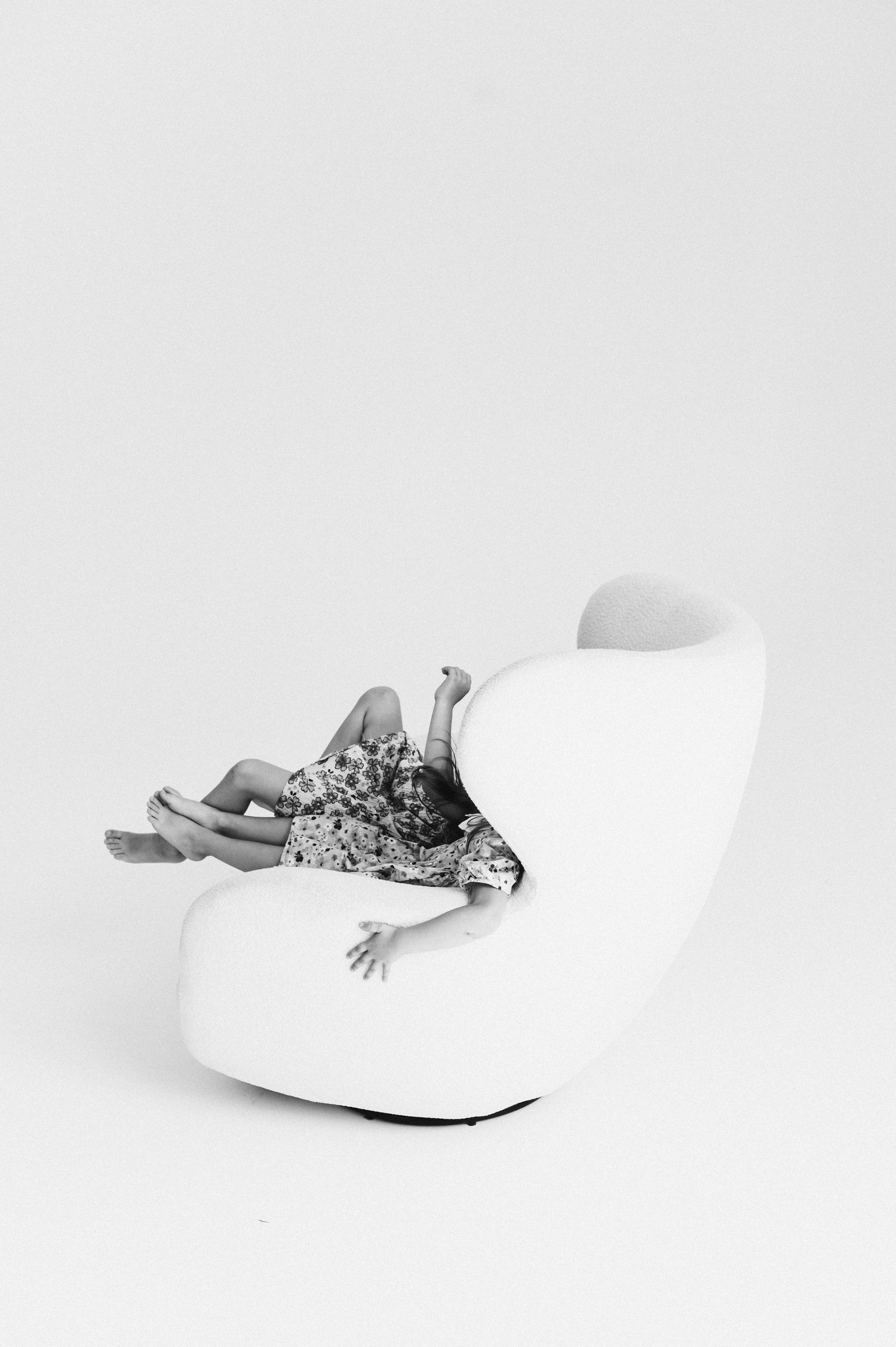Minimalist white studio photos showing abstract poses on white furniture.