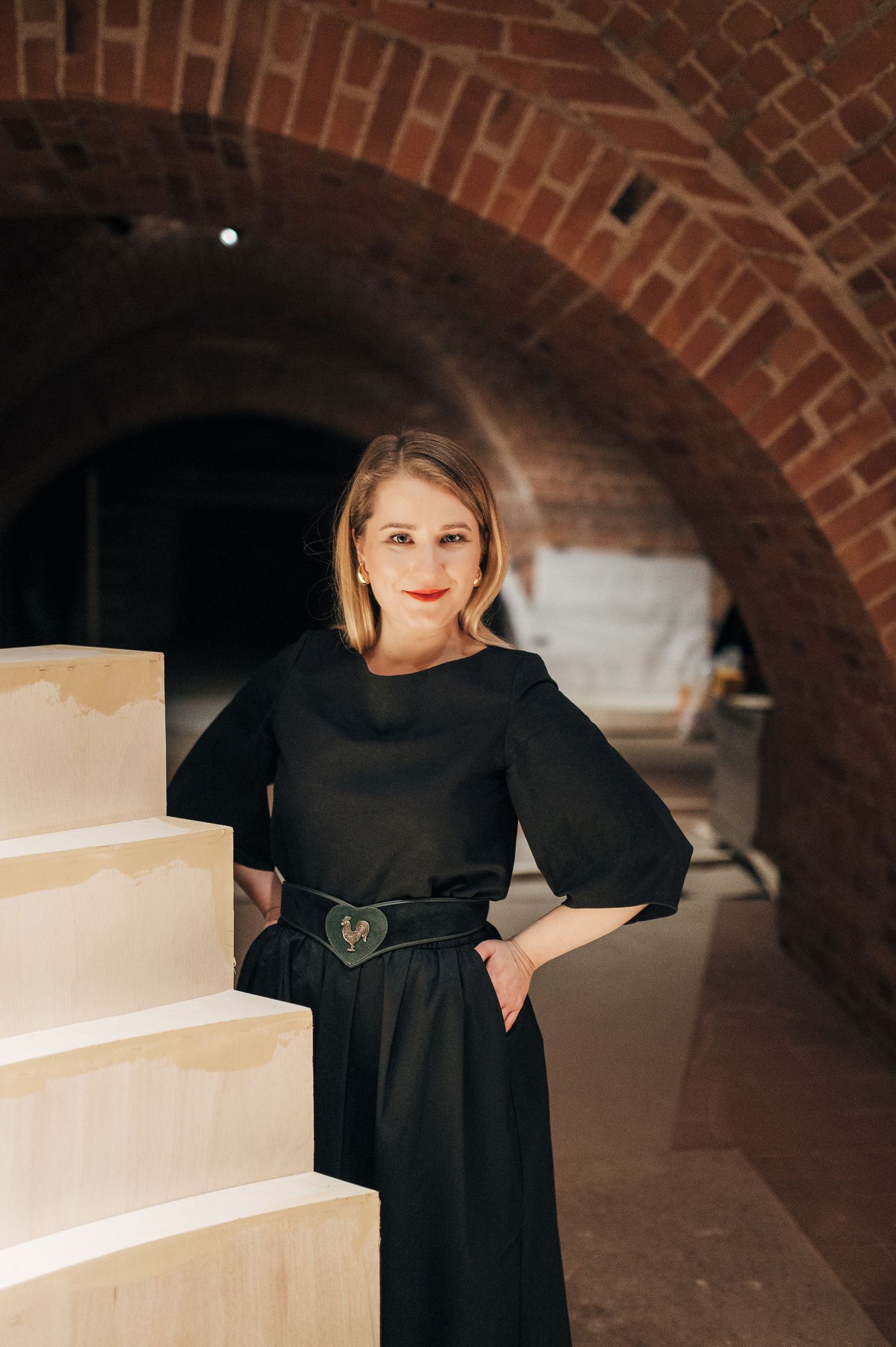 Rustic brick archway interior with modern black dress styling.