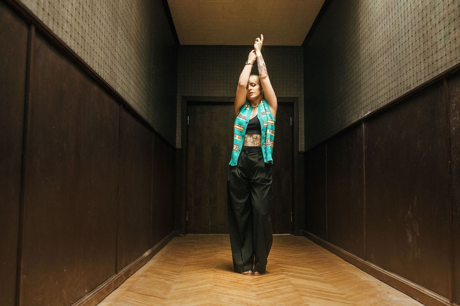Dramatic indoor photography sequence in a dark corridor with turquoise accents.
