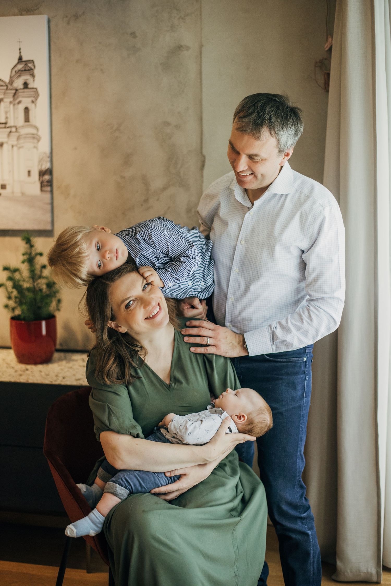 Family sharing tender moments on couch with newborn baby.