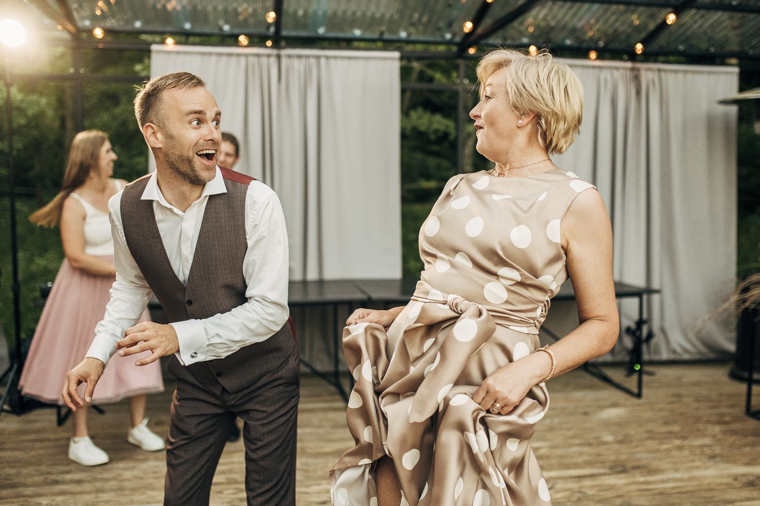 Elegant wedding reception with guests in formal attire dancing and celebrating.