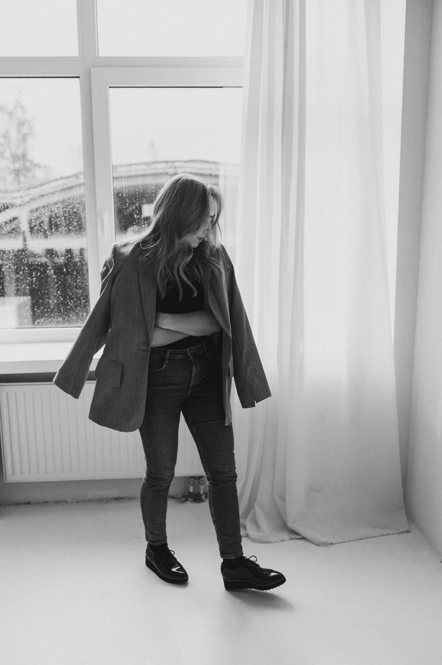 Artistic black and white photos showing legs and feet walking near bright windows.