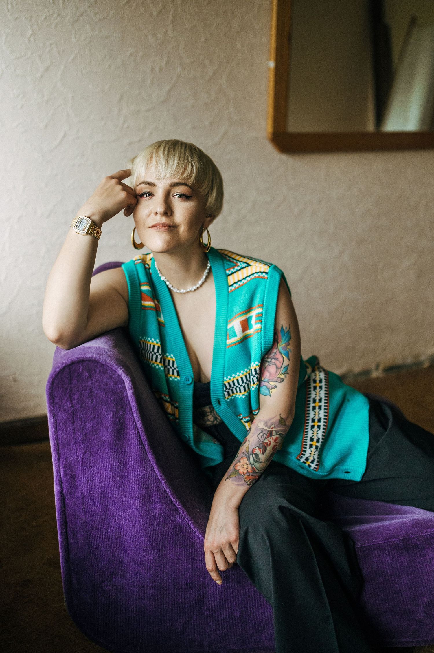 Interior fashion portrait series on a purple velvet couch featuring a turquoise vest.