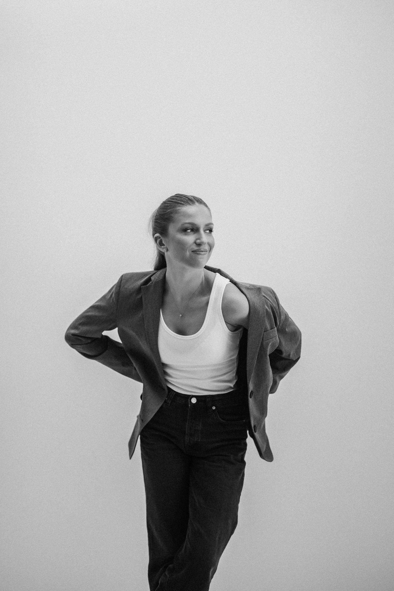 Black and white fashion portrait showing a casual outfit with oversized blazer, white tank top and dark pants.