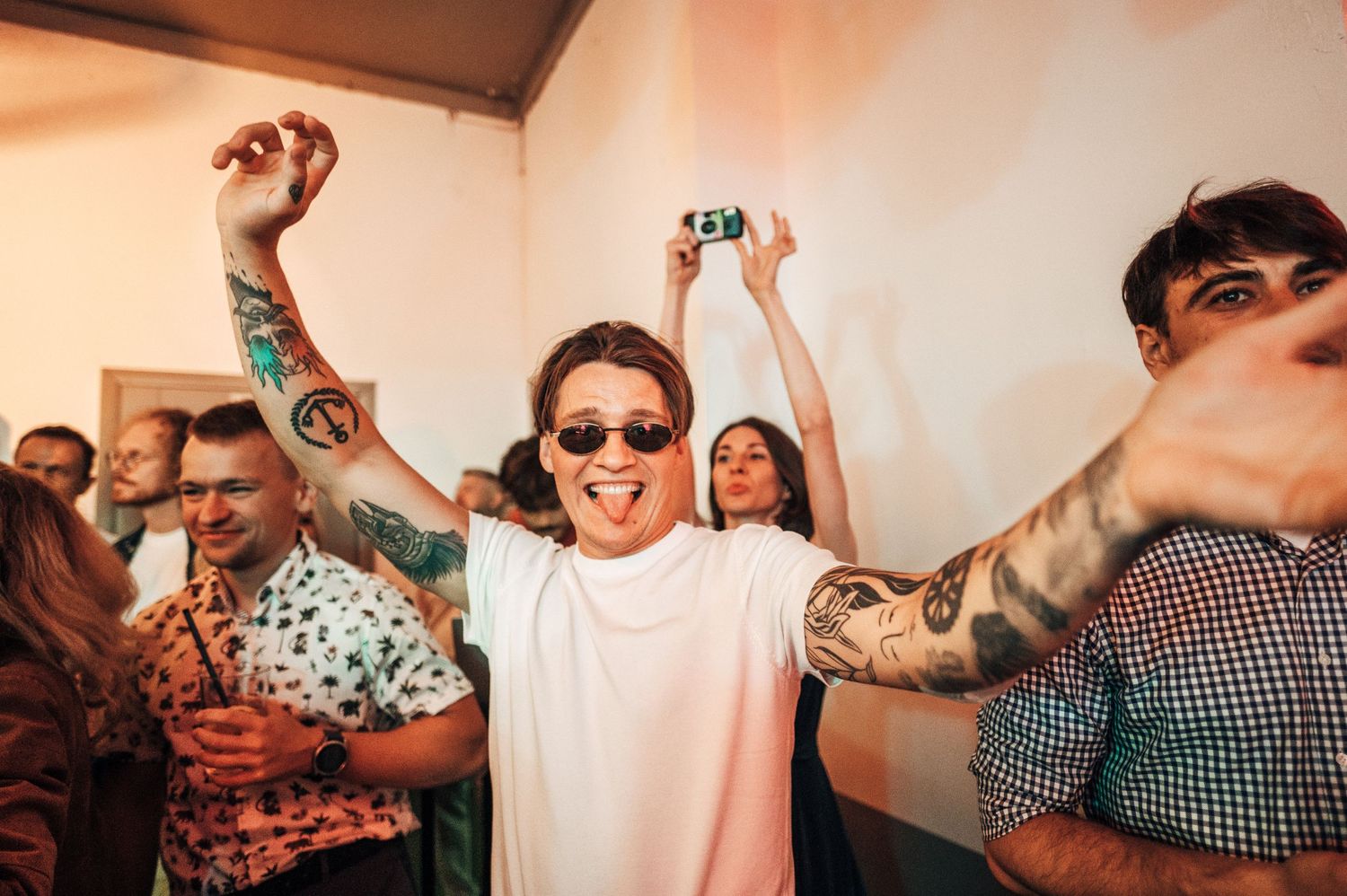 Energetic dance party celebration with guests wearing sunglasses.