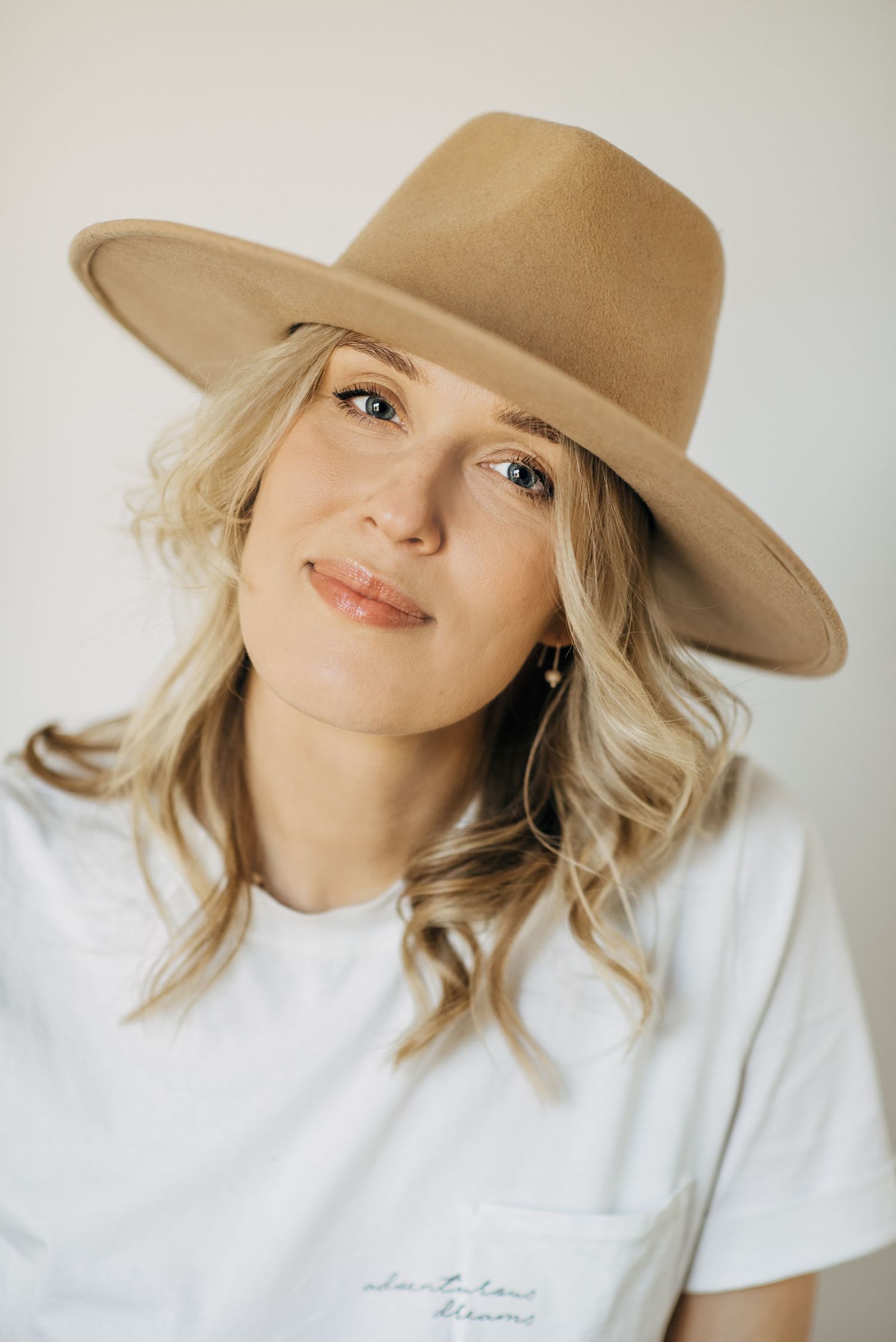 Lifestyle portraits featuring tan fedora hat and white t-shirt against neutral background.