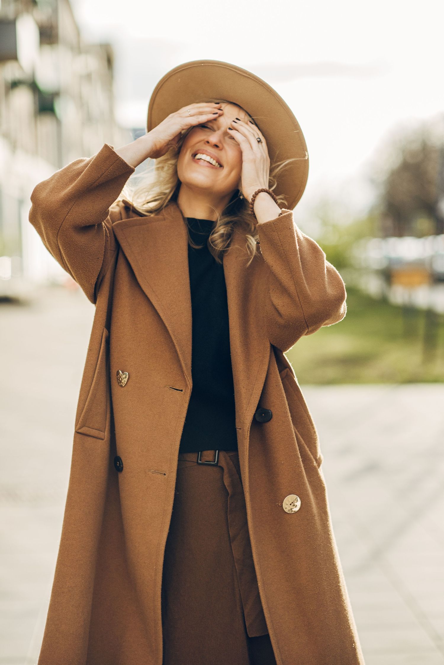 Stylish autumn fashion shots showcasing an oversized camel coat in an urban setting.