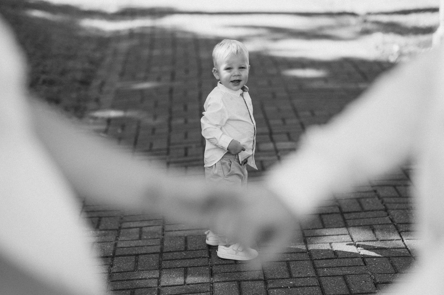 Artistic black and white photo shows movement across brick pavement with blurred edges.