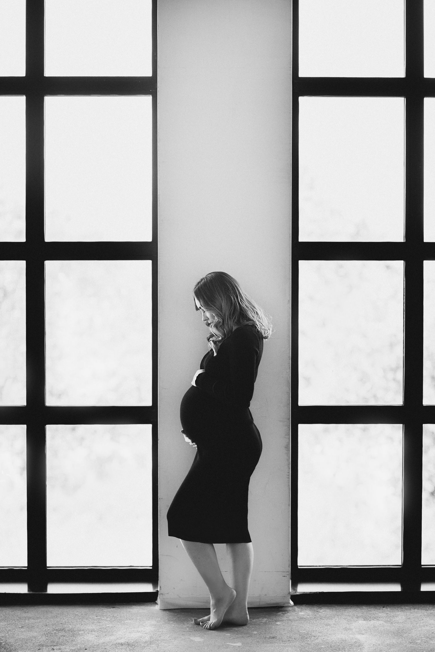 Artistic black and white series showing silhouette against geometric window patterns.