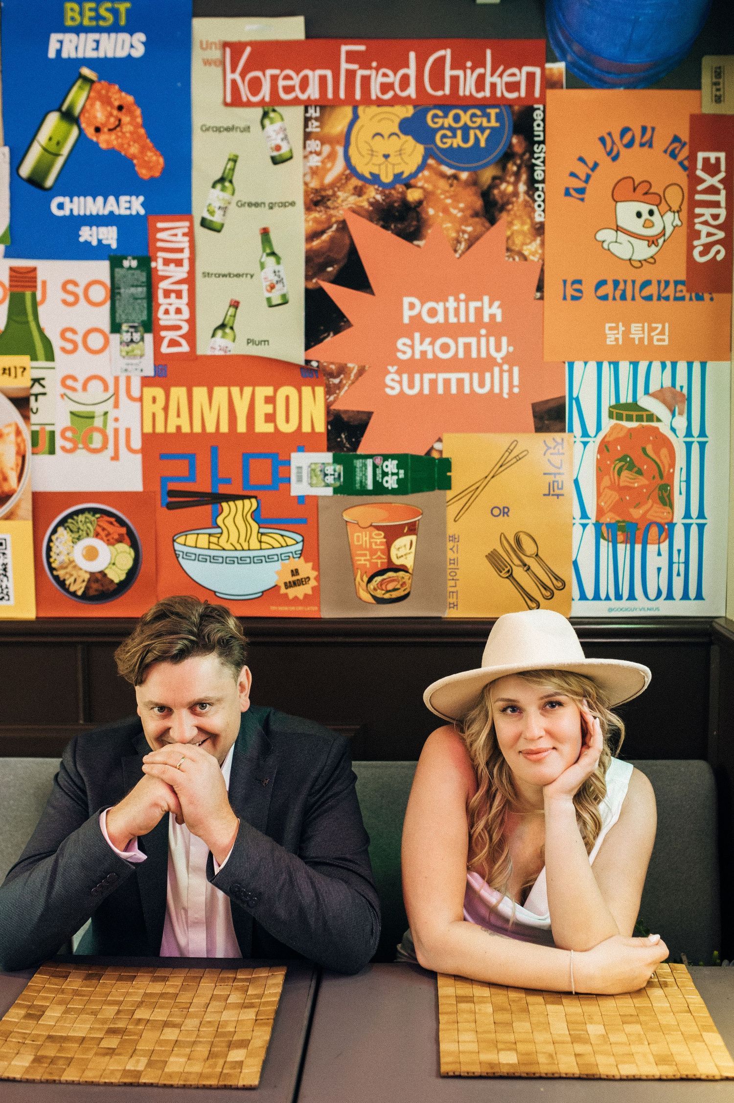 Sequence of candid shots showing couple laying heads on wooden table with colorful wall art in background.