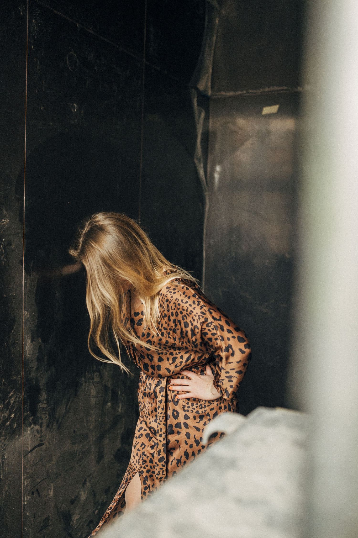 Person wearing leopard print outfit photographed through white bars.