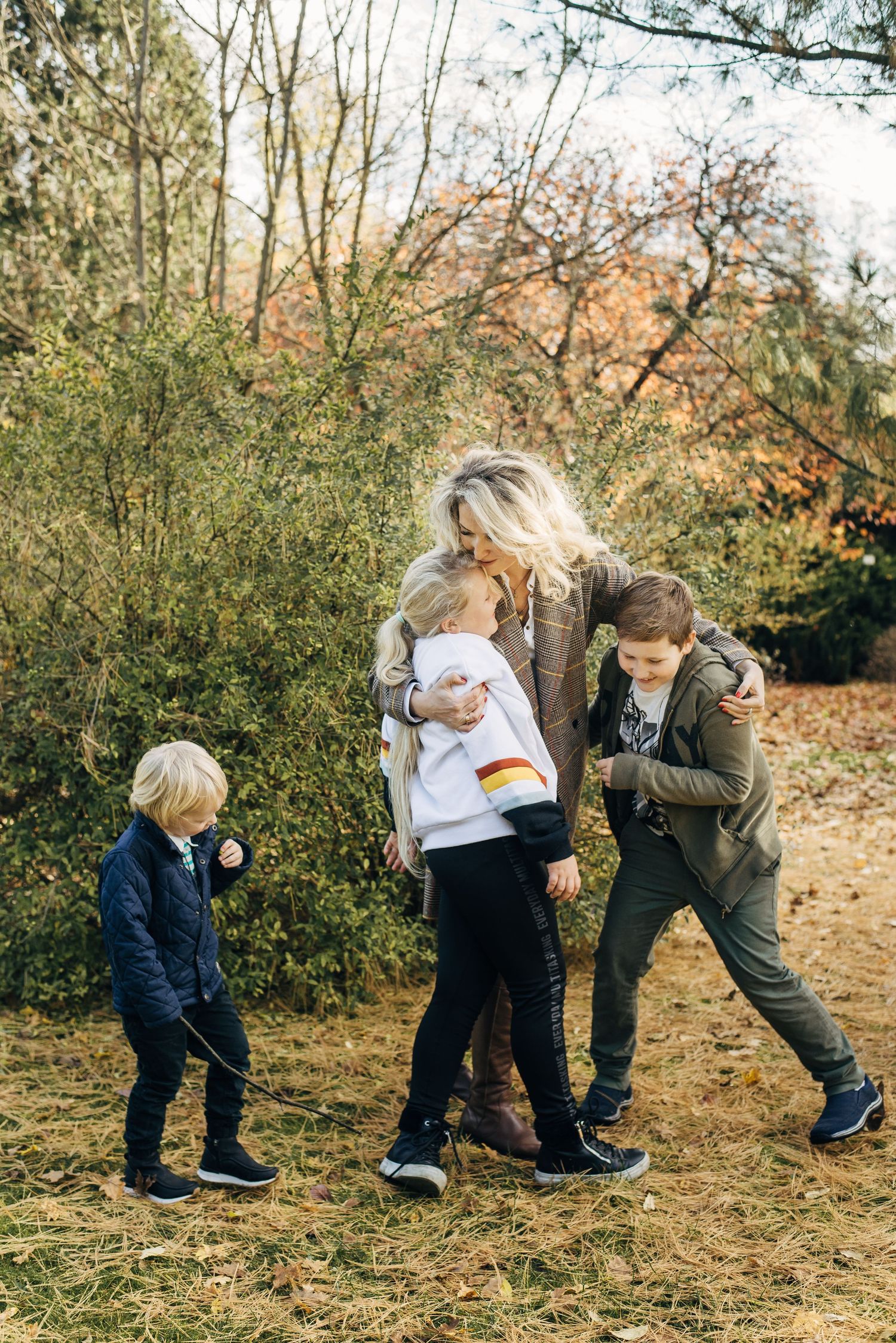 Family group walking together on an autumn trail surrounded by fall foliage.