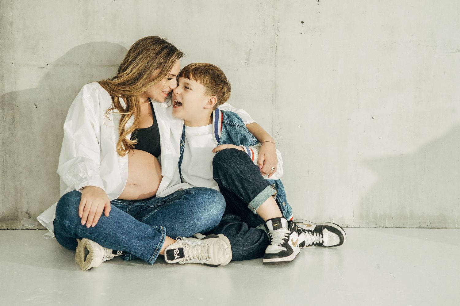 Sweet candid moments between mother and child on white background.