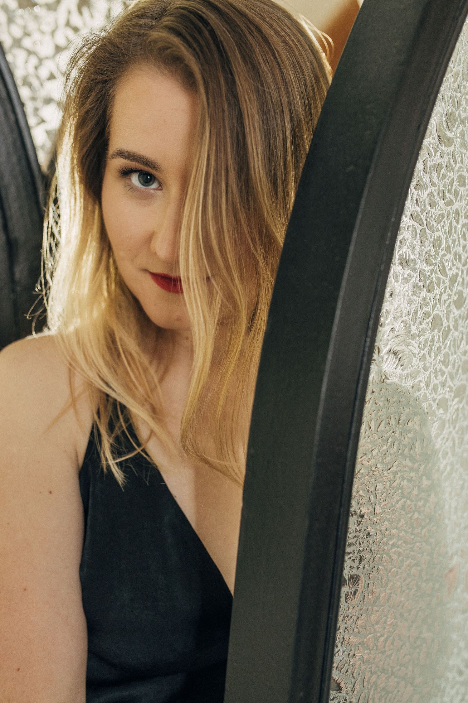 Woman in black posing artistically against a textured background.