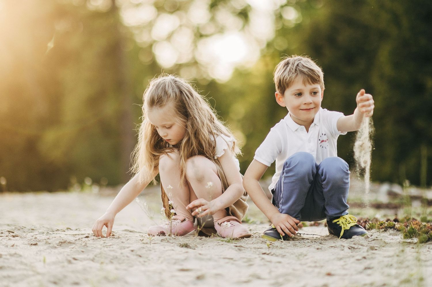 Children playing together outdoors in bright sunlit garden setting.