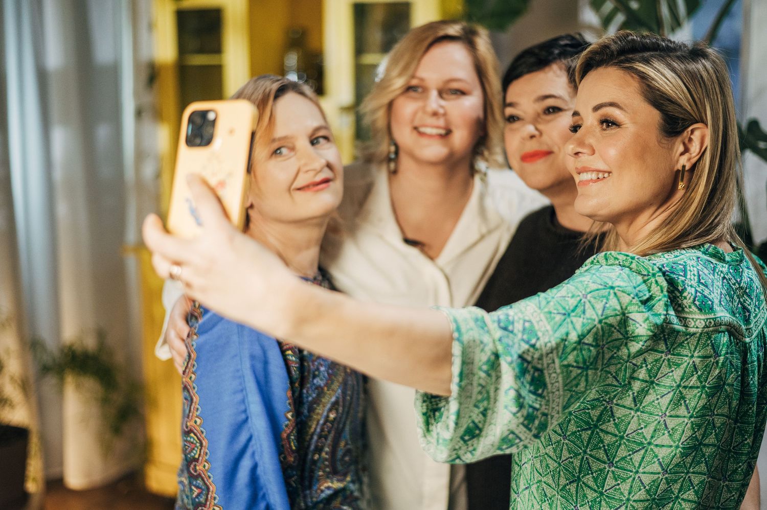 Group of friends taking a selfie together at an indoor gathering.