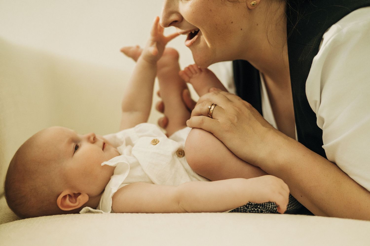 Close-up intimate moments between parent and baby in soft natural light.