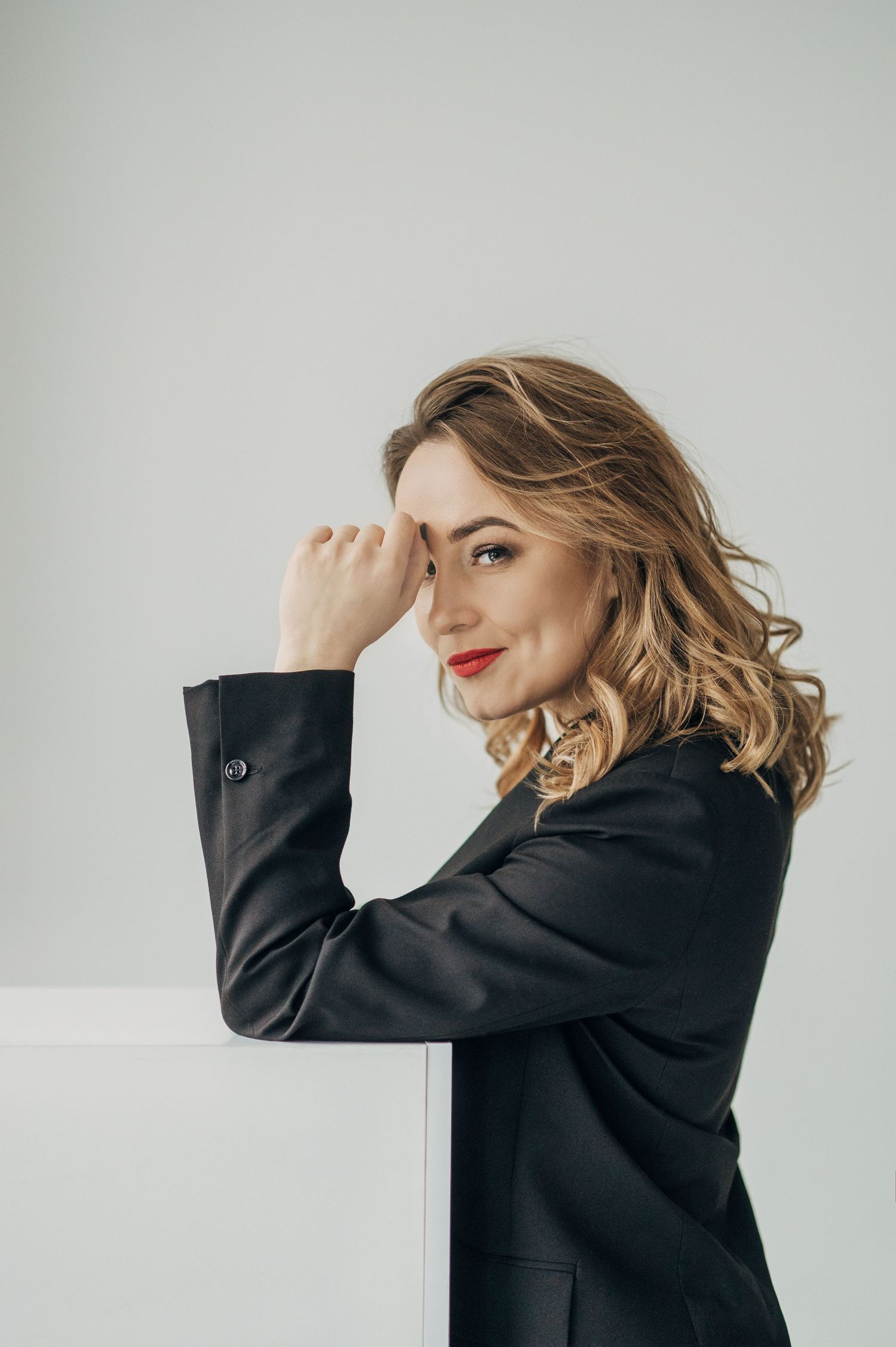 Elegant black blazer fashion series against light grey backdrop.