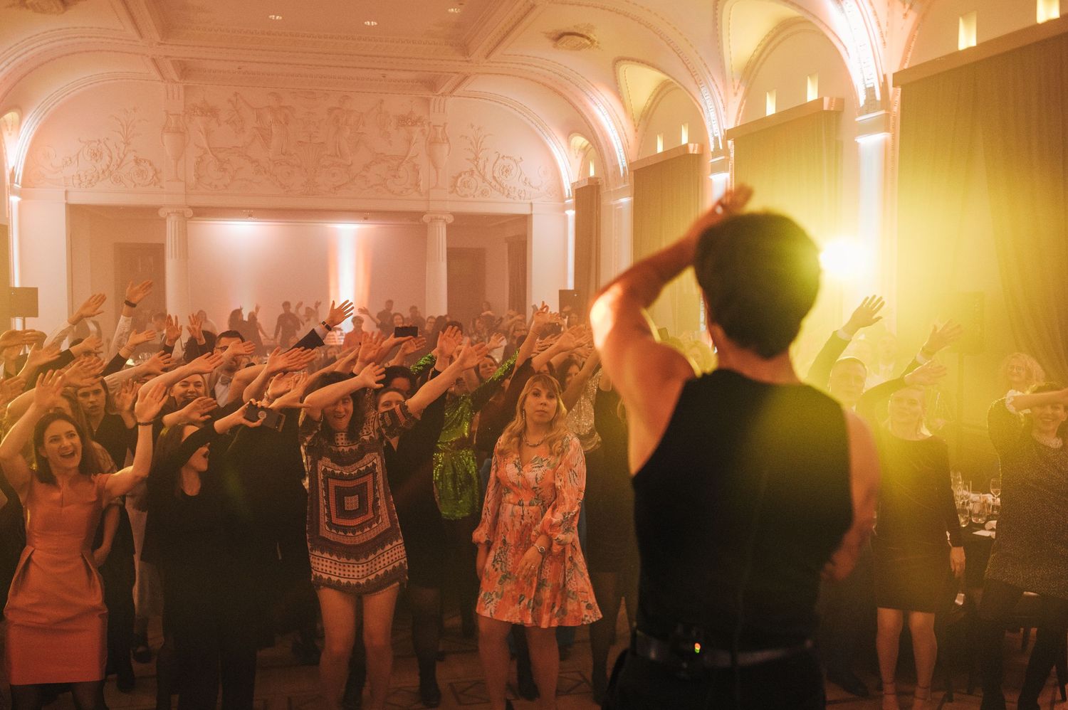 Crowd enjoying an evening event in an elegant venue with warm lighting.