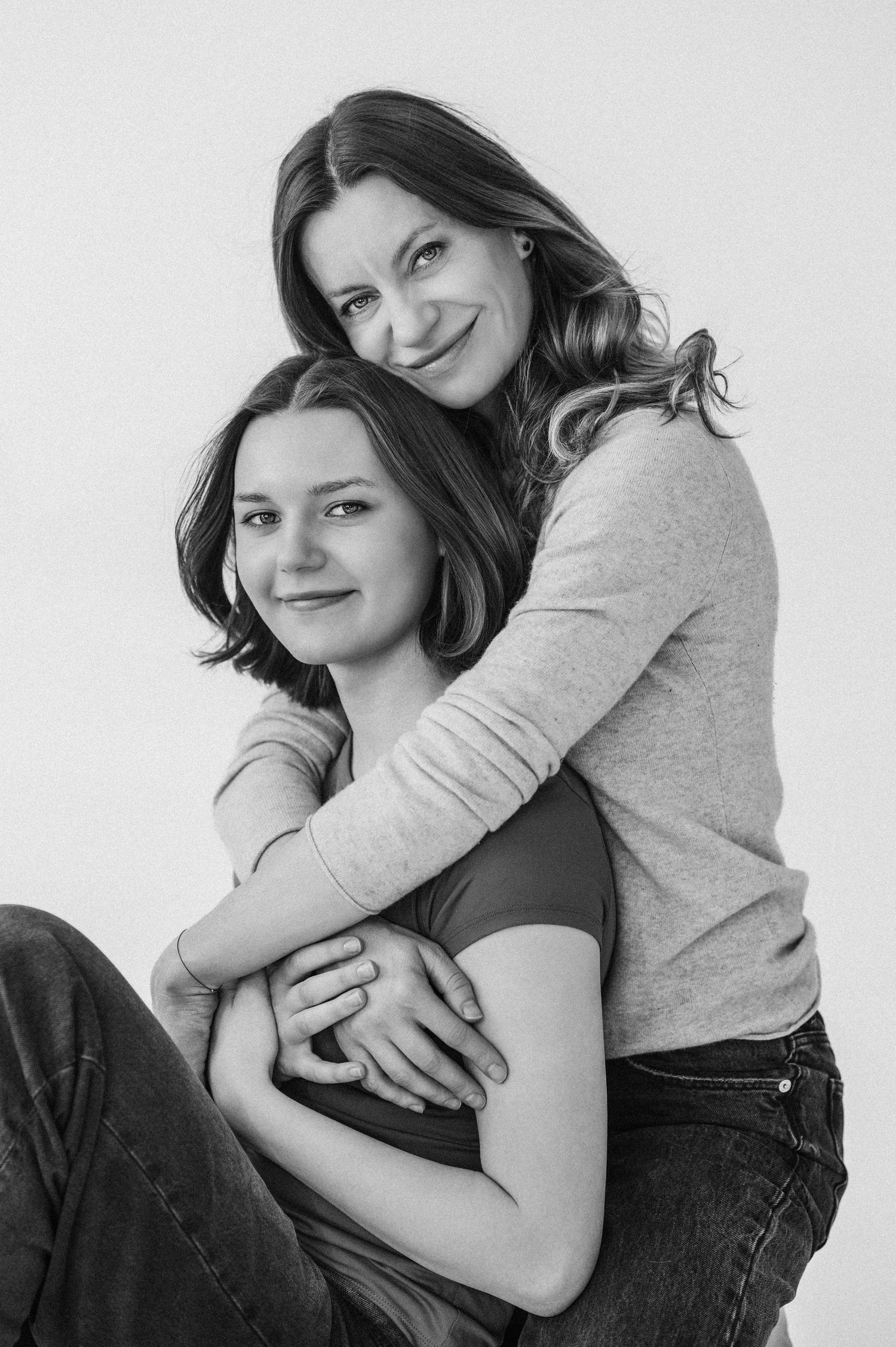 Two people share an intimate embrace in a black and white portrait photo.