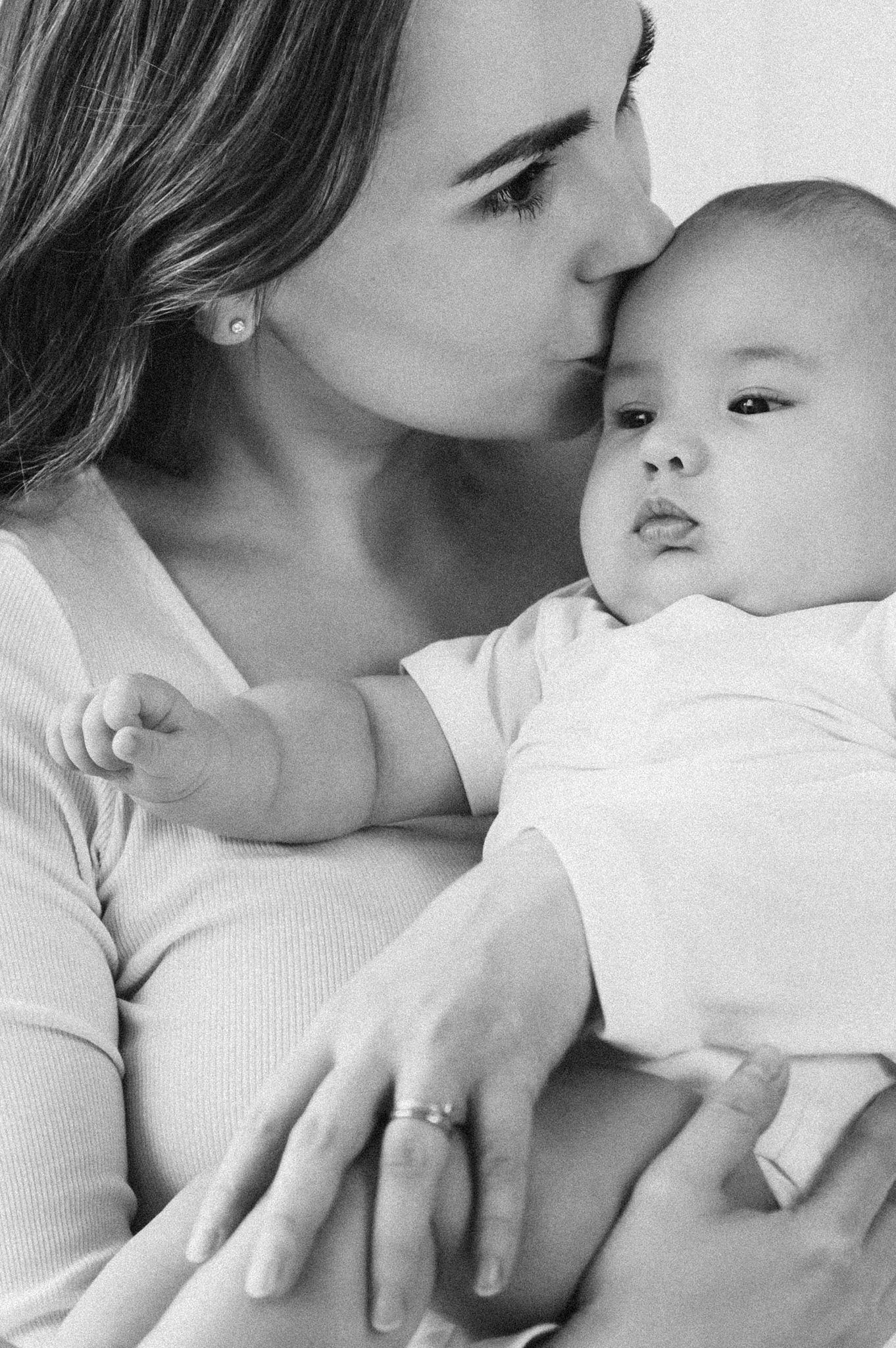 Intimate black and white series showing tender moments between parent and baby.