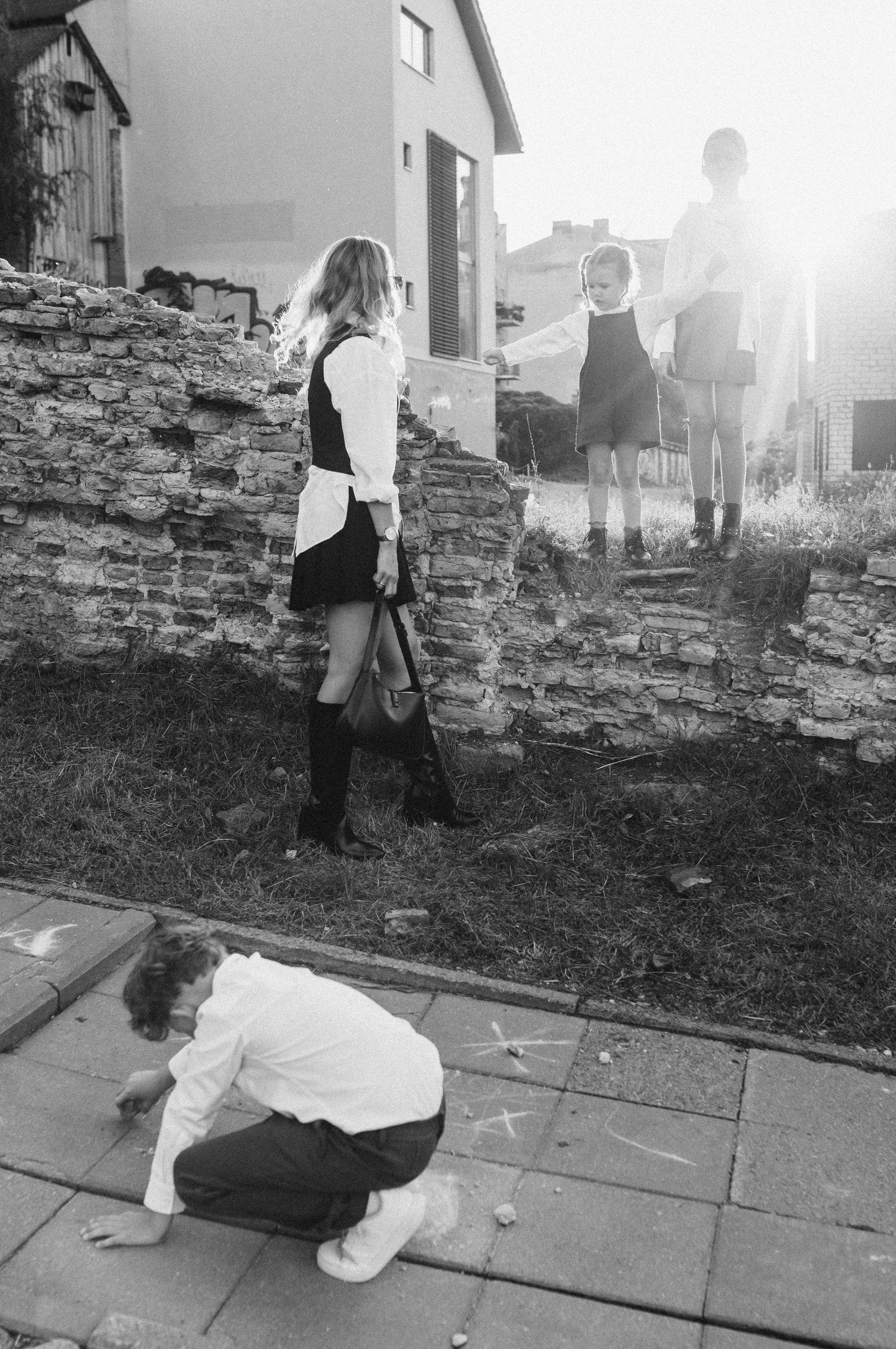 Black and white photo series showing silhouettes playing against a stone wall at sunset.