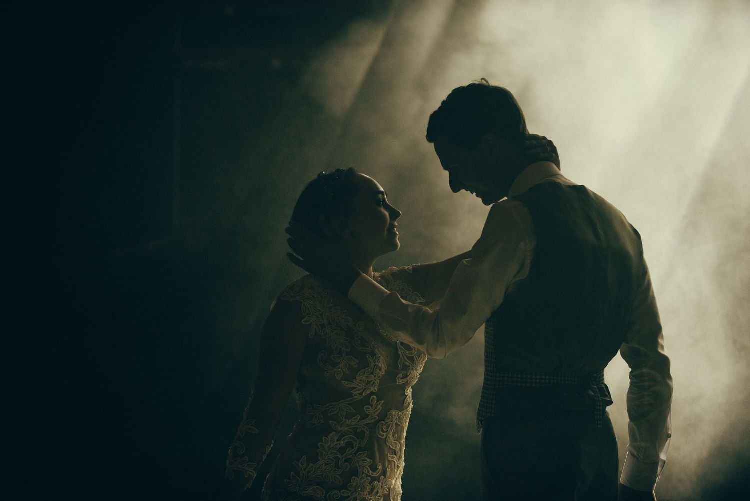 Silhouetted figures dance in atmospheric lighting creating a moody party atmosphere.