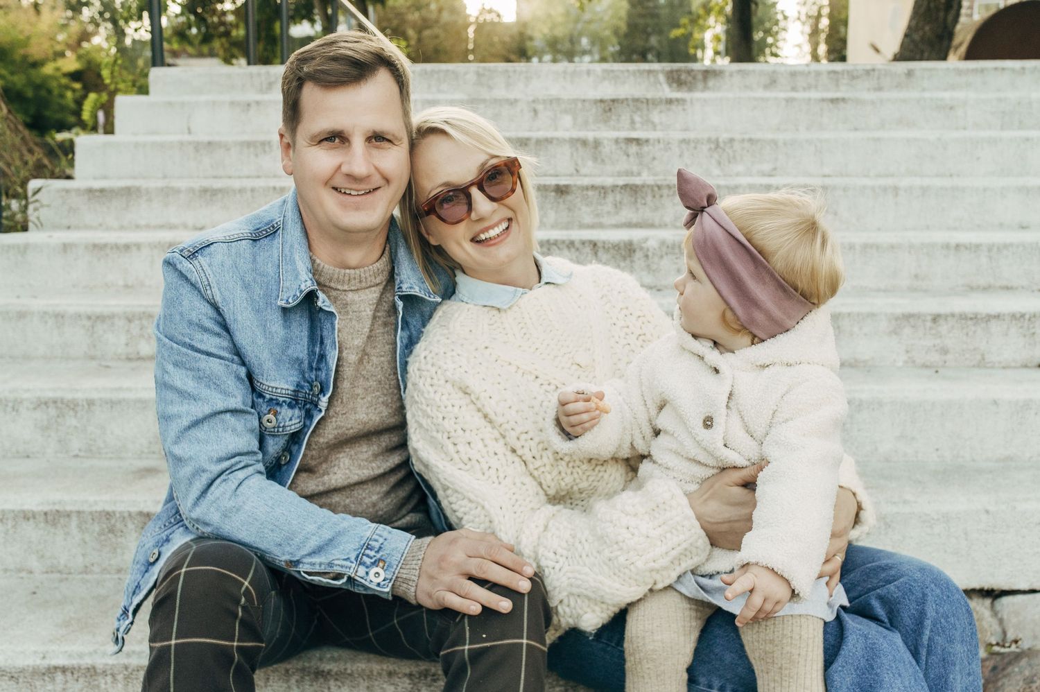 Family photo sequence on white stone steps during golden hour showing joyful interactions.