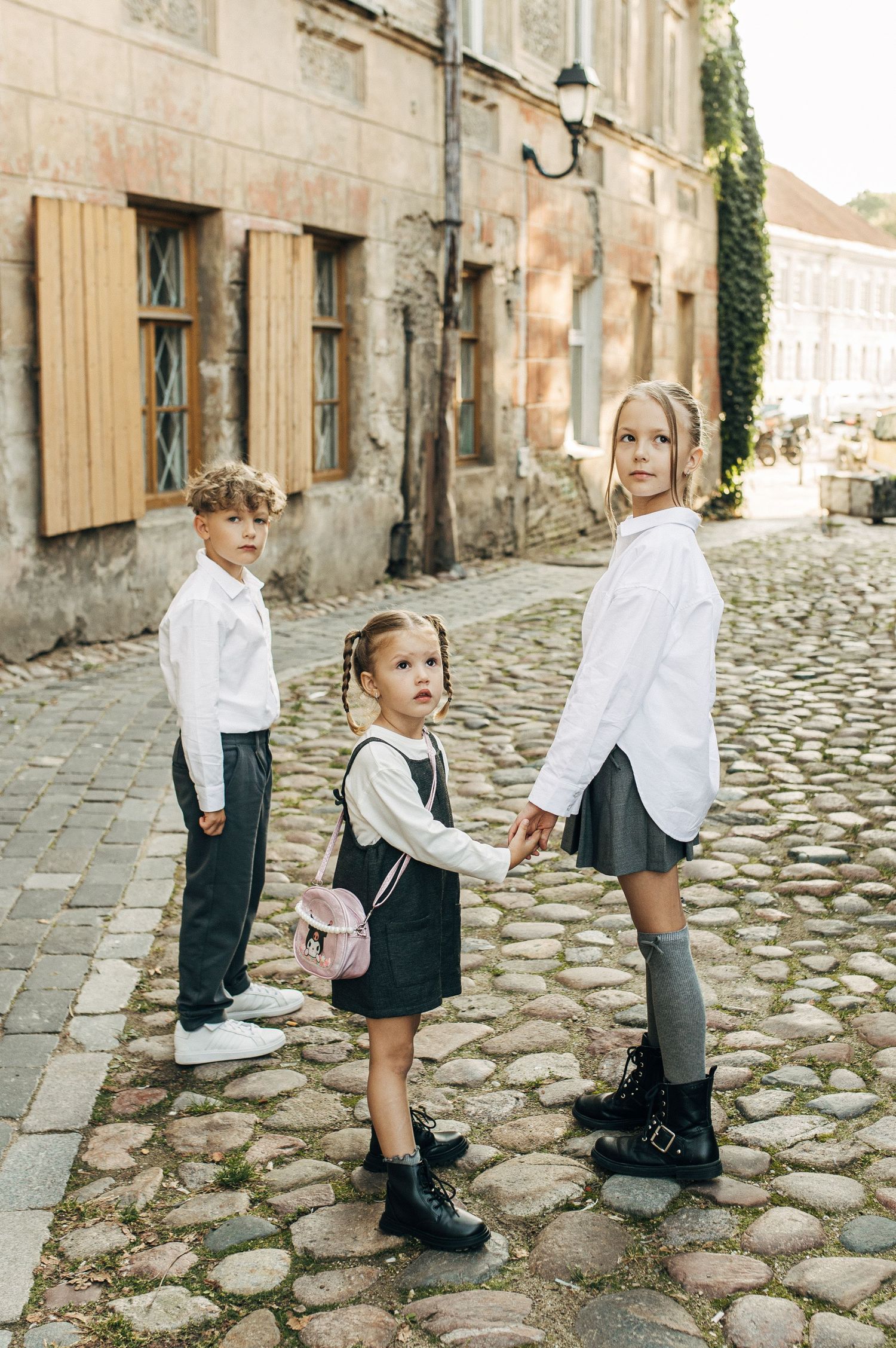 Children playing on a historic cobblestone street in front of old buildings.