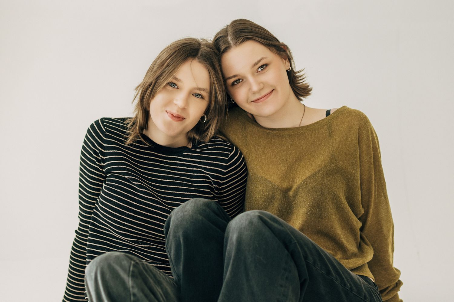 Candid studio shots of people wearing casual outfits sharing warm embraces.