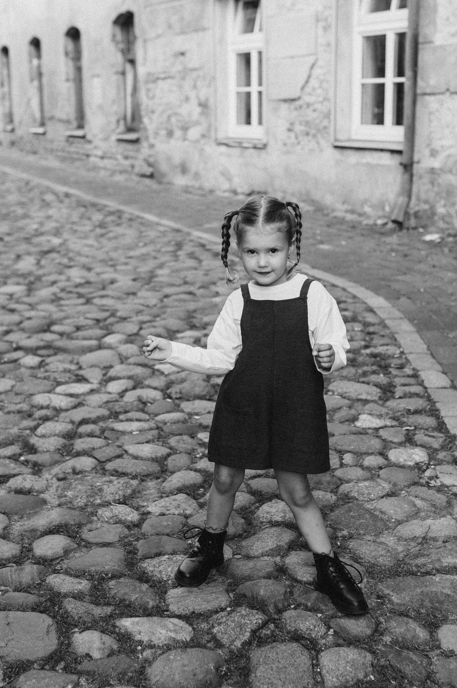 Documentary style photos of a child playing on an old cobblestone street.