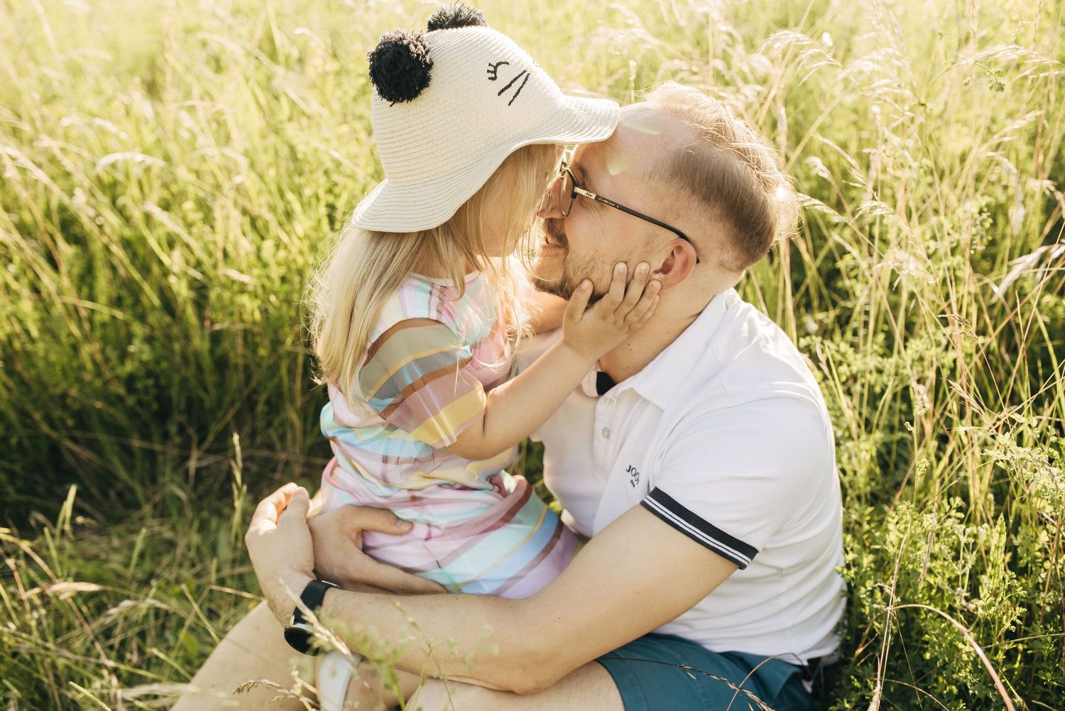 A tender family moment shared between parent and child in a golden sunlit field.