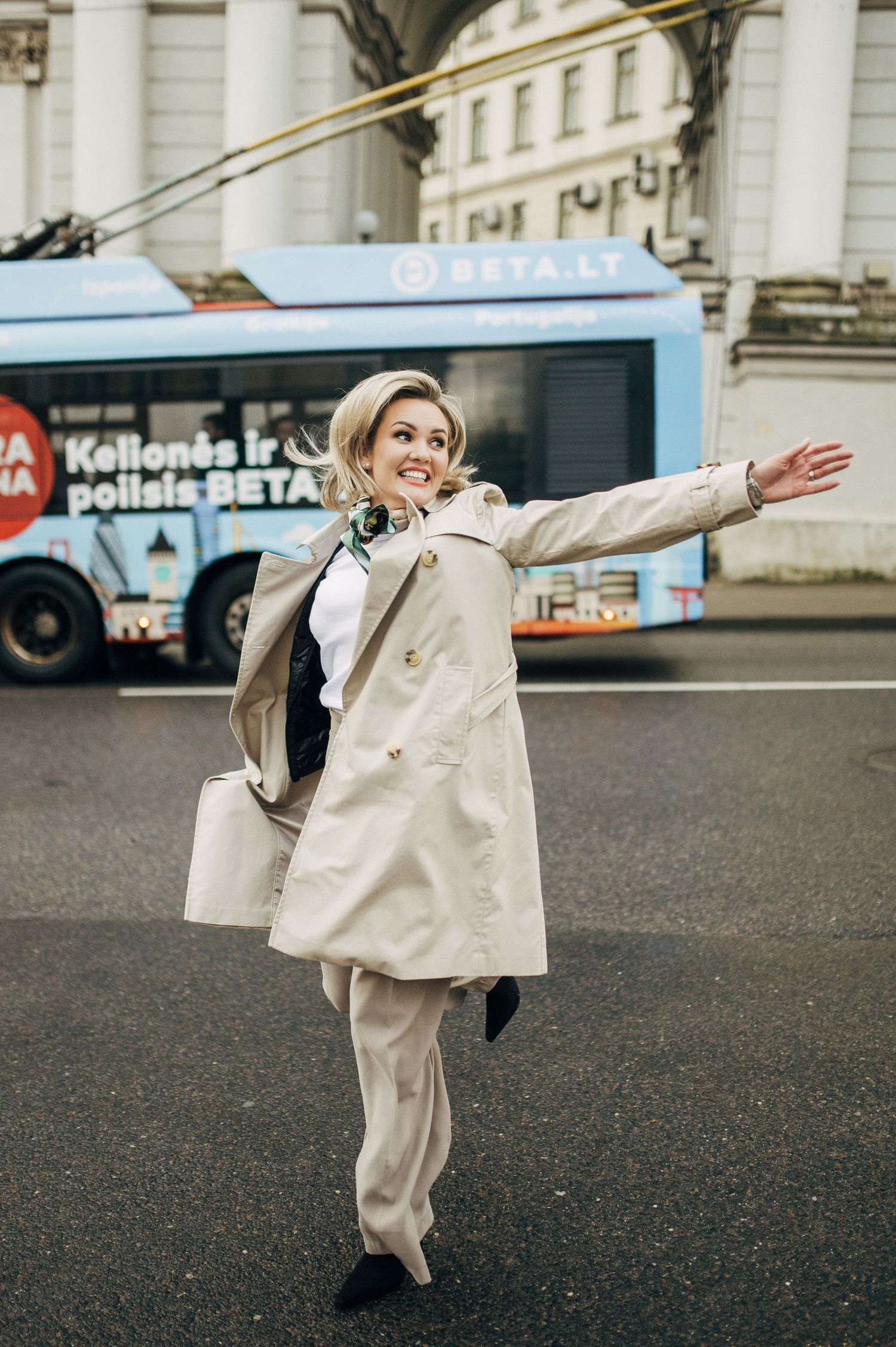 Figure in white outfit performs dynamic dance moves on urban street.