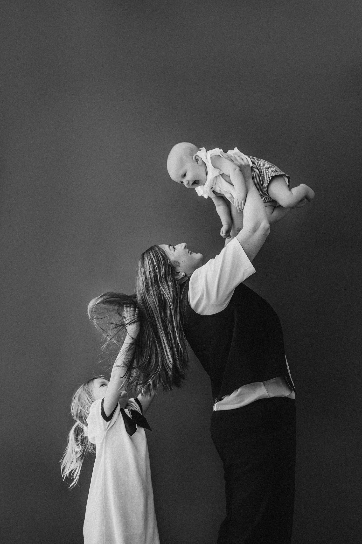 Black and white portrait series capturing intimate parent-child moments.