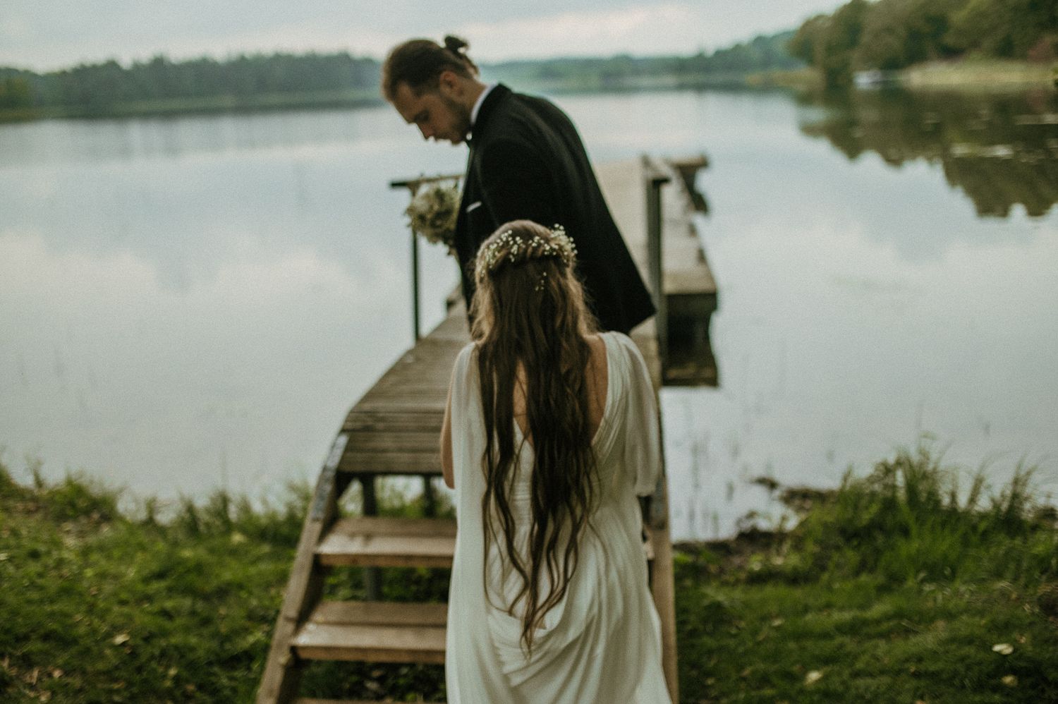 A scenic lakeside photoshoot with a wooden dock and calm waters in the background.