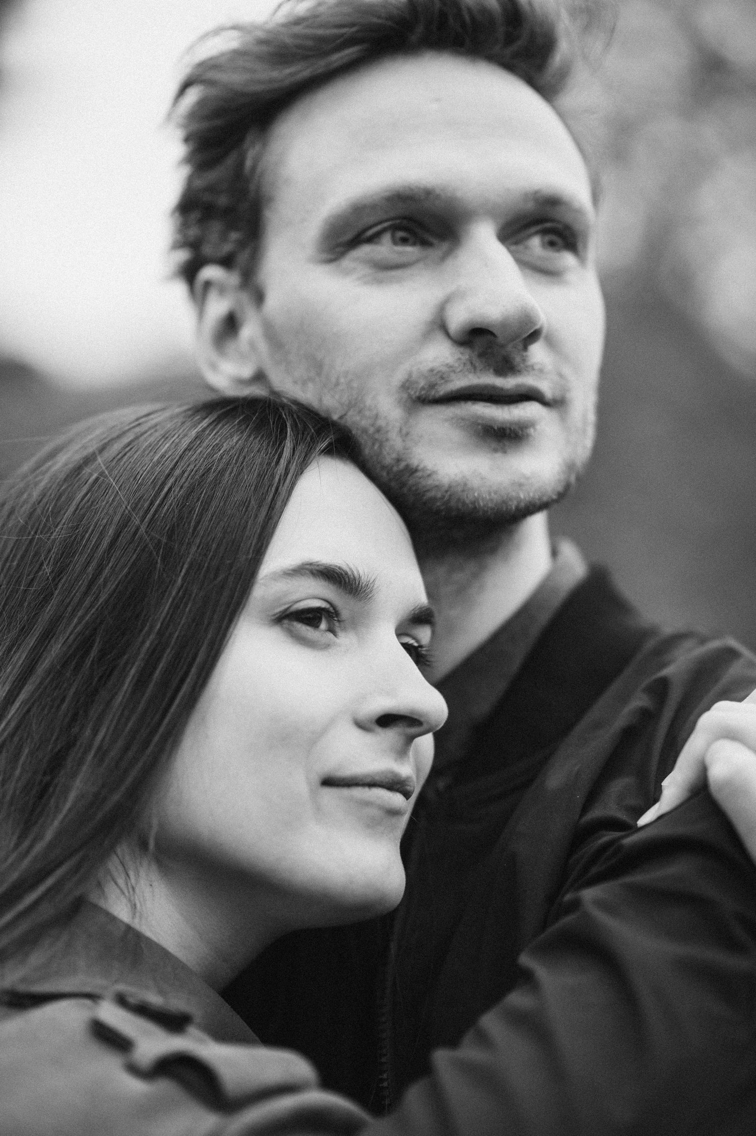Close up black and white portrait of couple looking up with dreamy expressions.