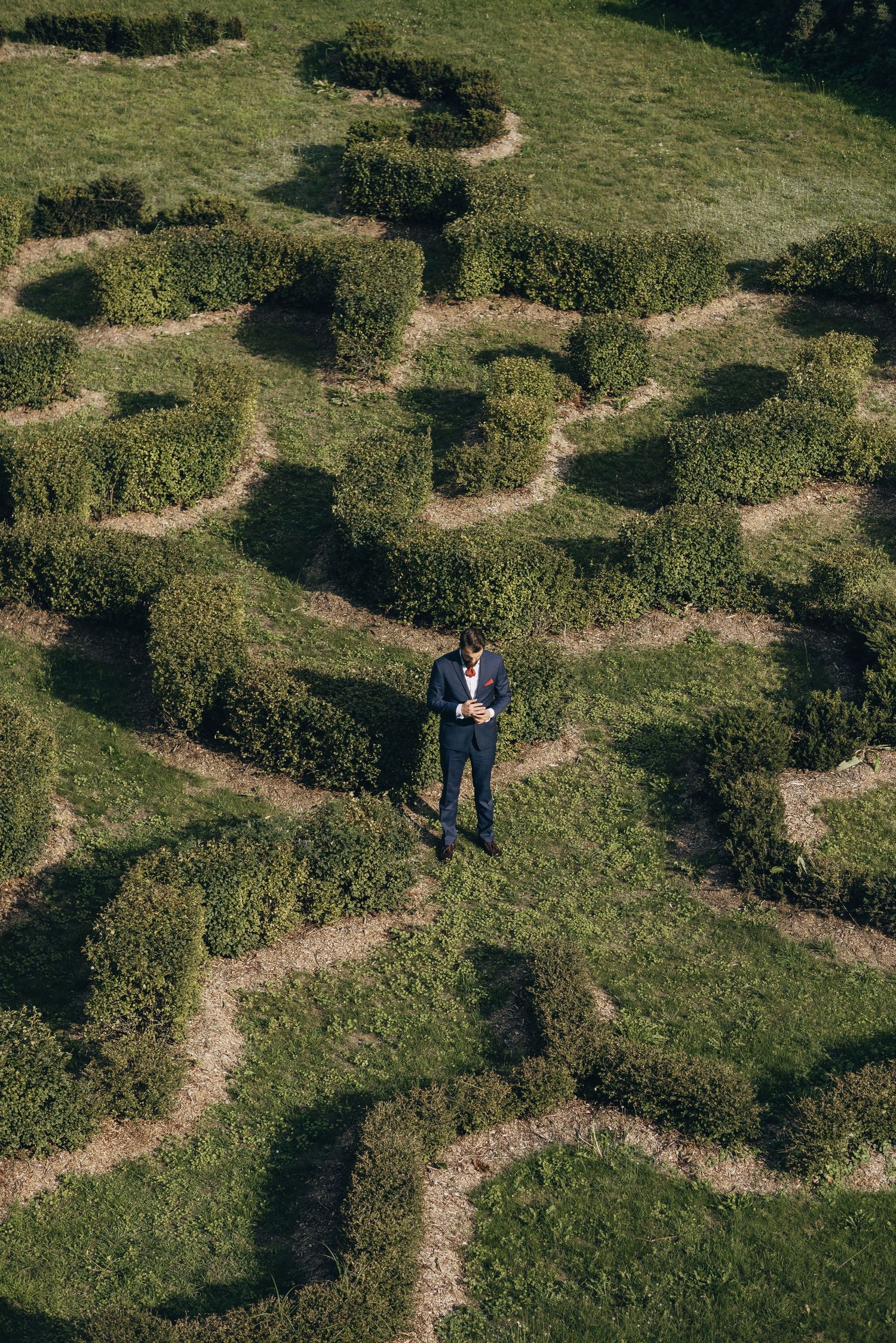 Aerial view of winding paths through green grass creating geometric patterns.