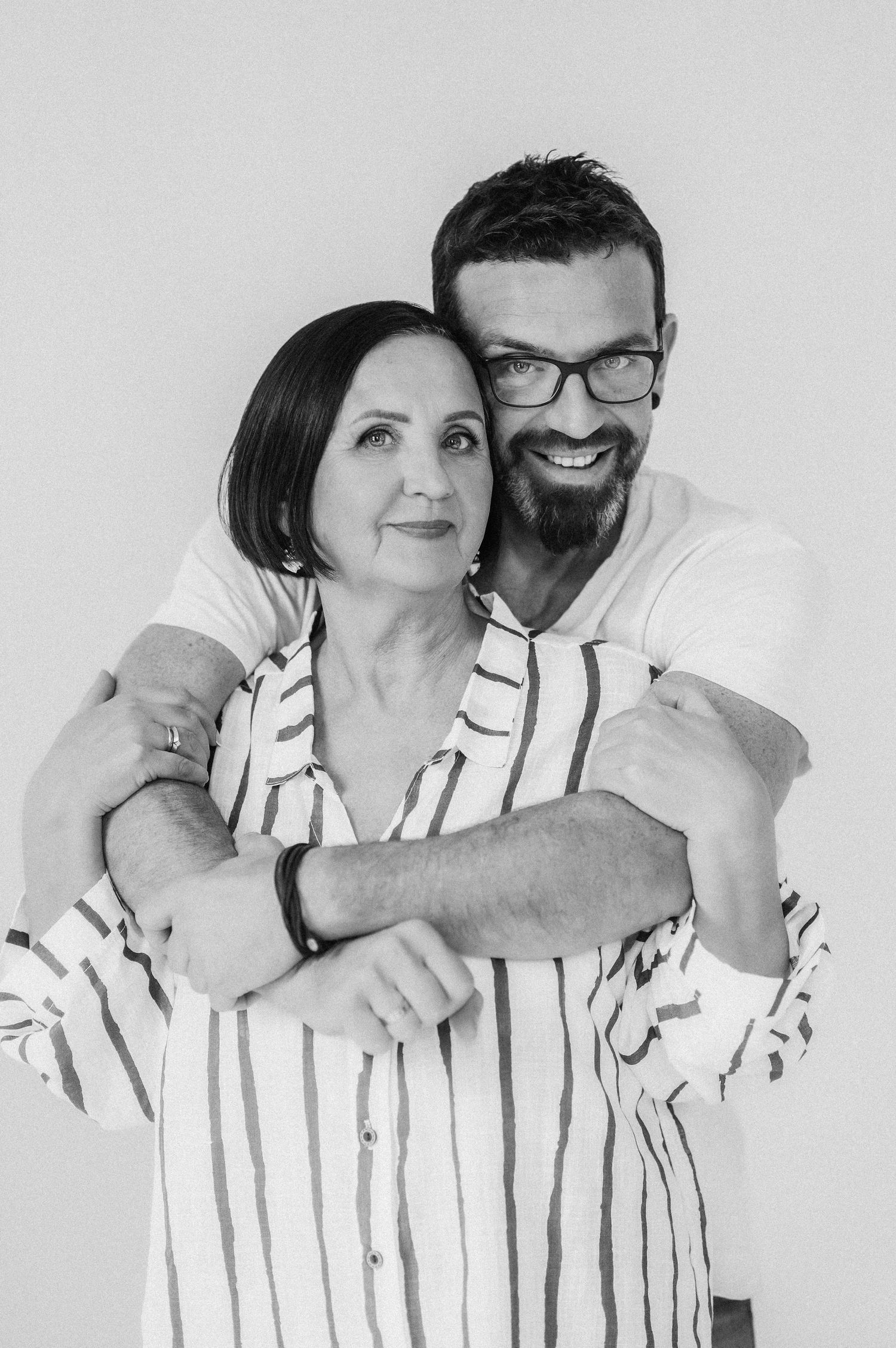 Progressive shots of a couple in striped clothing sharing affectionate moments against a white background.
