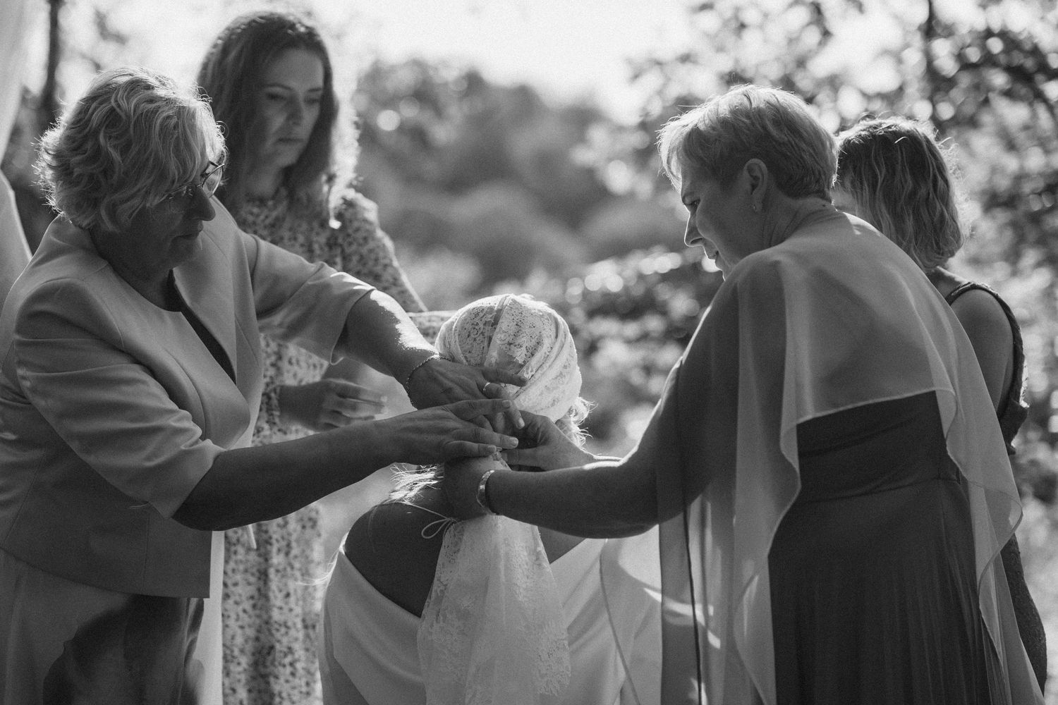 Black and white photo of couples dancing together at an outdoor event in formal attire.